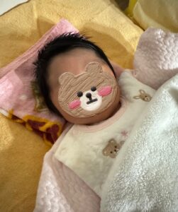 あの夜に着せていたものと同じ綿入りロンパース姿の新生児