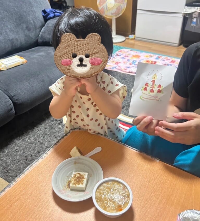1歳の誕生日に、鰹節パウダーをかけた豆腐ティラミス風を食べる娘